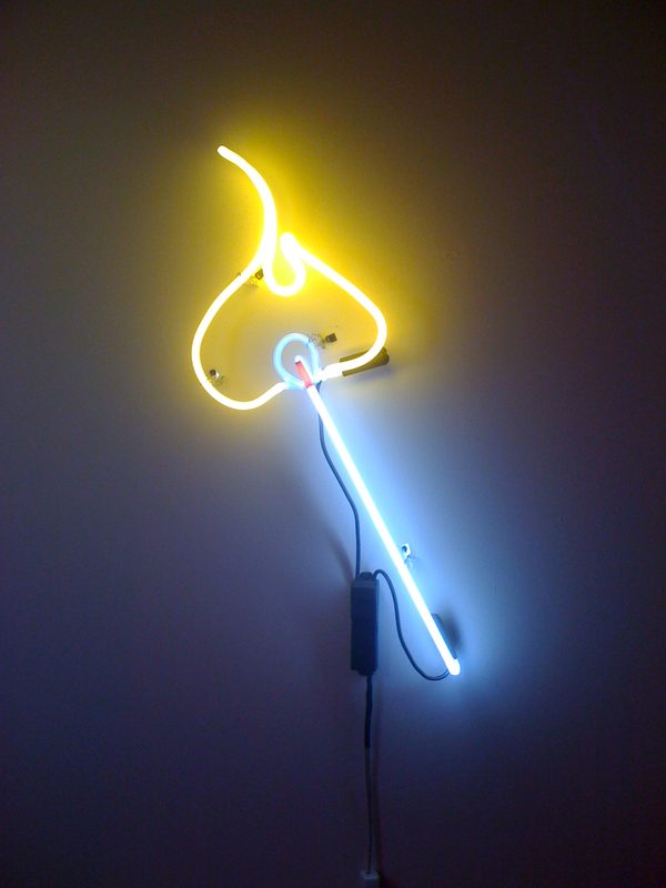 Yellow neon flame atop a pale blue neon stick, mounted on a white wall
